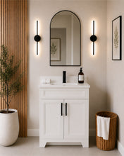 Pearl 24" white bathroom vanity with black hardware and white quartz countertop, styled in a modern bathroom with wood slat accent wall. 