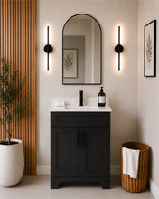 Pearl 24" black bathroom vanity with black hardware and white quartz countertop, styled in a modern bathroom with wood slat accent wall