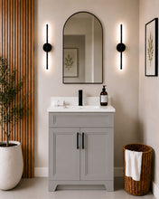 Pearl 24" light grey bathroom vanity with black hardware and white quartz countertop, styled in a modern bathroom with wood slat accent wall