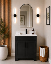 Pearl 30" black bathroom vanity with black hardware and white quartz countertop, styled in a modern bathroom with wood slat accent wall