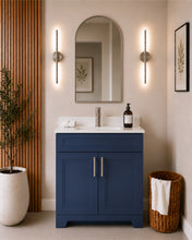 Pearl 30" navy blue bathroom vanity with brushed nickel hardware and white quartz countertop, styled in a modern bathroom with wood slat accent wall