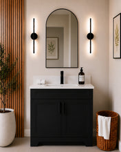Pearl 36" black bathroom vanity with black hardware and white quartz countertop, styled in a modern bathroom with wood slat accent wall