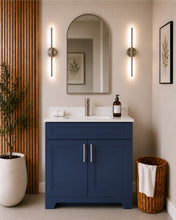 Pearl 36" navy blue bathroom vanity with brushed nickel hardware and white quartz countertop, styled in a modern bathroom with wood slat accent wall