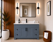 Pearl 54" dark grey bathroom vanity with four drawers, black hardware and white quartz countertop, styled in a modern bathroom with wood slat accent wall