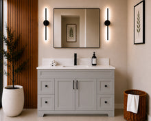 Pearl 54" light grey bathroom vanity with four drawers, black hardware and white quartz countertop, styled in a modern bathroom with wood slat accent wall