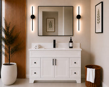 Pearl 54" white bathroom vanity with four drawers, black hardware and white quartz countertop, styled in a modern bathroom with wood slat accent wall